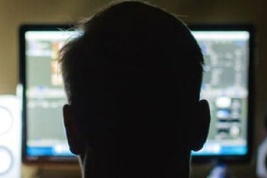Back of person's head looking at computer screen.