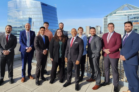 group of eleven people standing outside on the roof of a building.