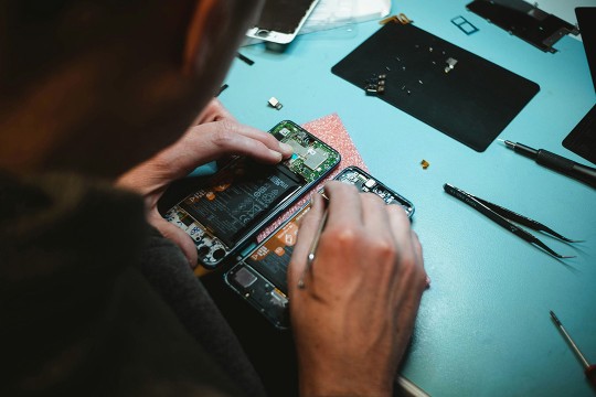 a man is shown working on the inside of a cell phone.