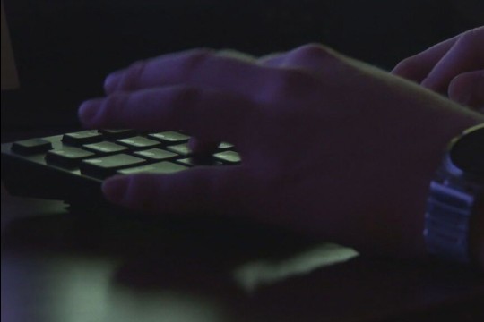 hands typing on a keyboard.