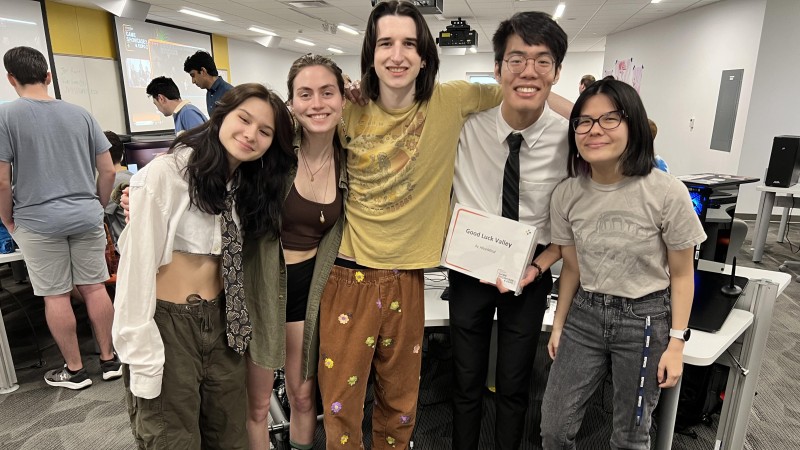 group of students posing in a lab smiling with a certificate