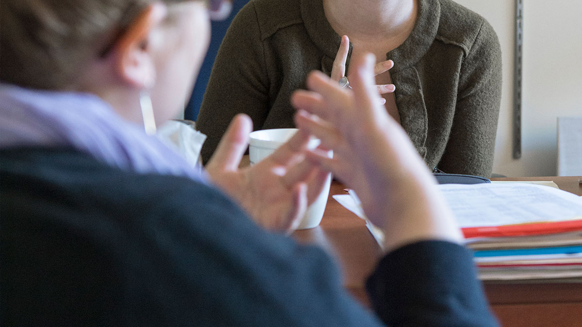 Two people having a conversation over coffee.