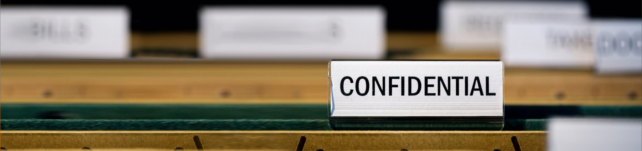 A view of several folders in a drawer, with one marked 'confidential' in focus.