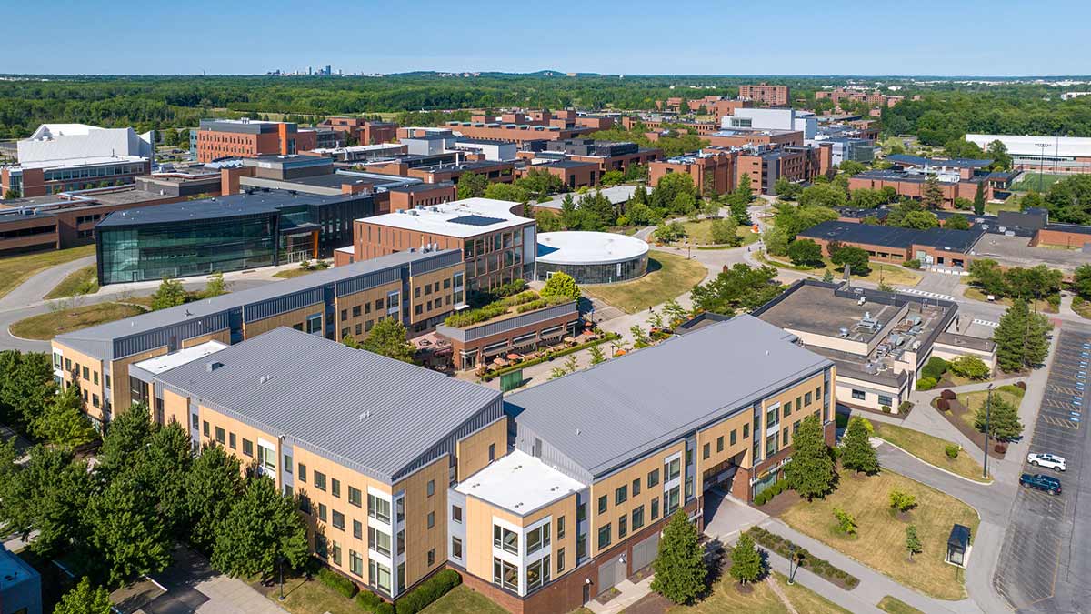 drone view of several brick and glass buildings on the R I T campus.