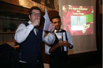 Two men in a shirt and vest at an auction