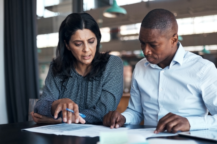 Two people talking while reviewing a document at a table
