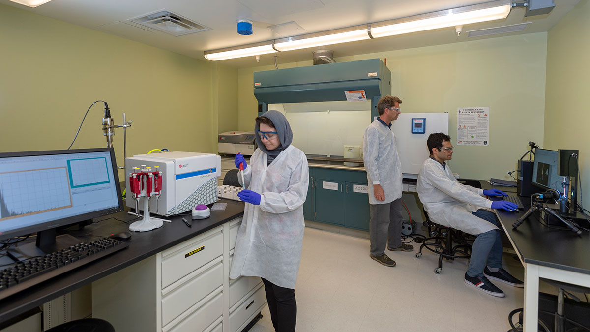 three people working in a lab.
