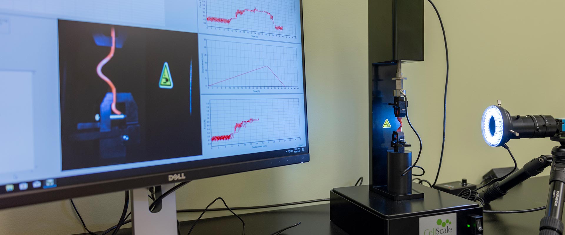close up of camera recording a close up of cell scale reading and data relating displaying on a graph on a computer monitor
