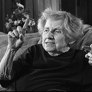 Doris Fedrid sitting on a couch pointing up