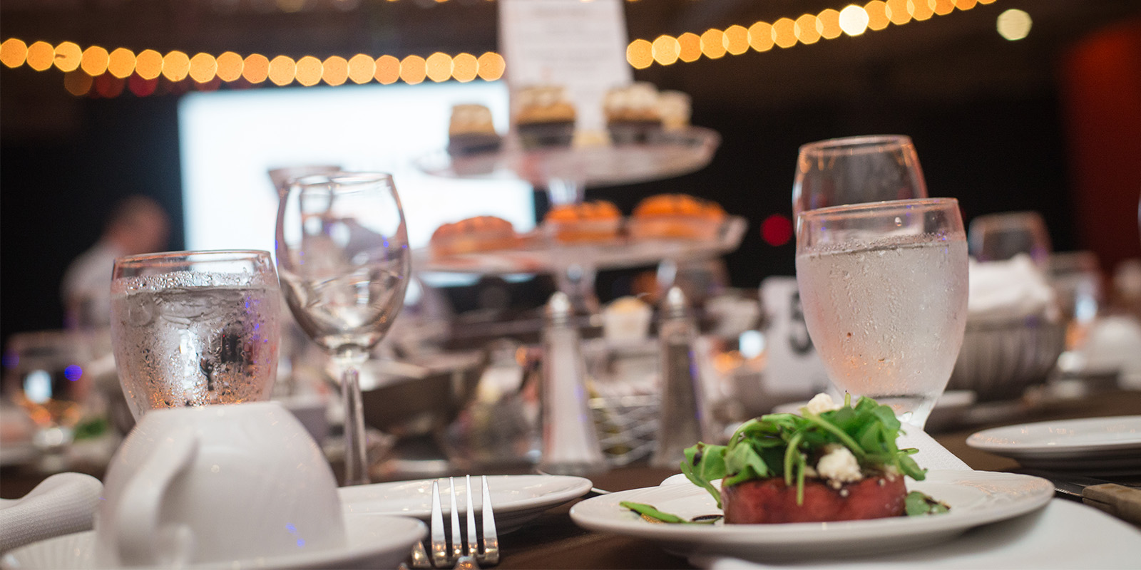 Table with glasses of water and a plate with food on it