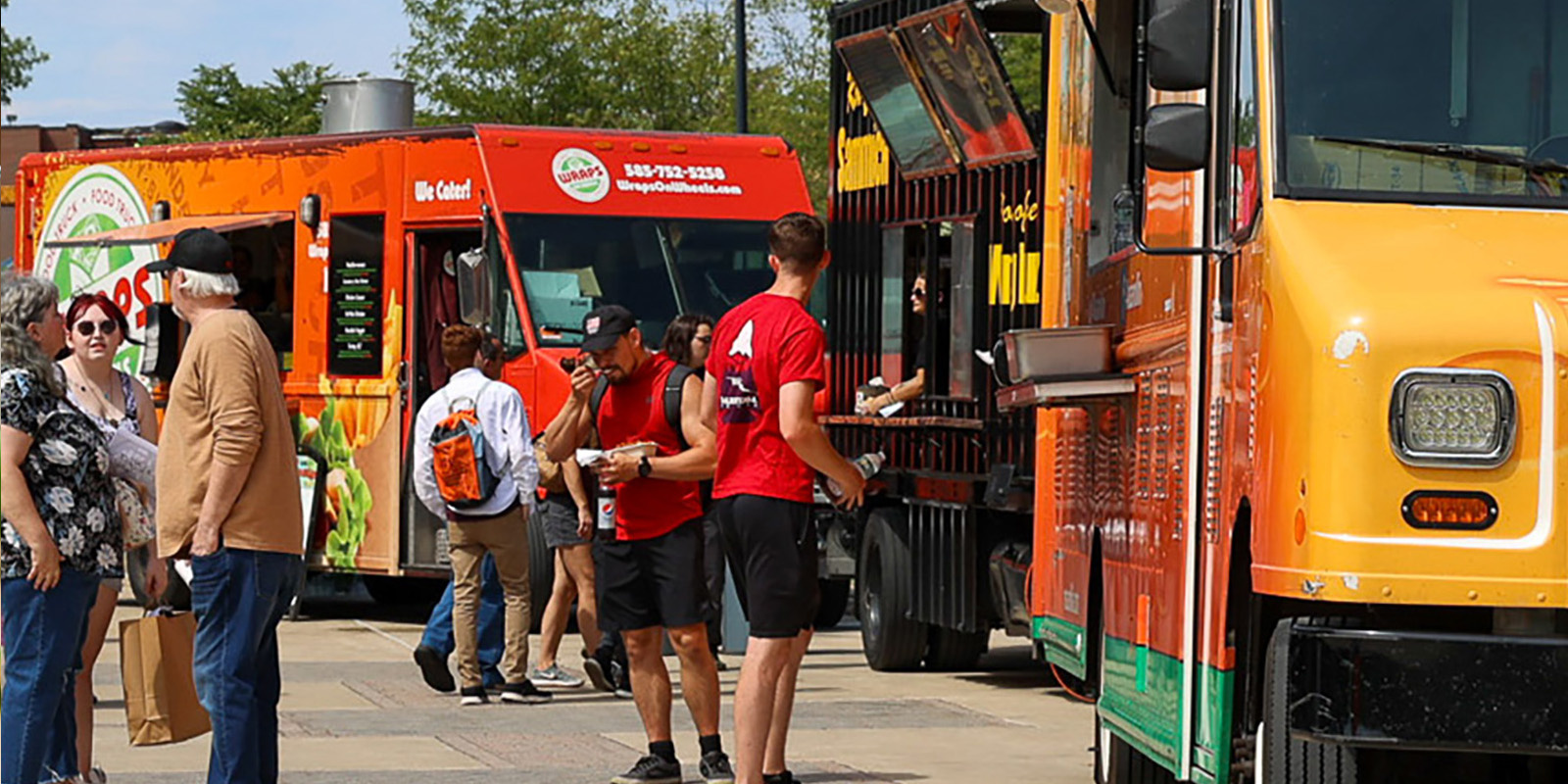 people in front of food trucks outside