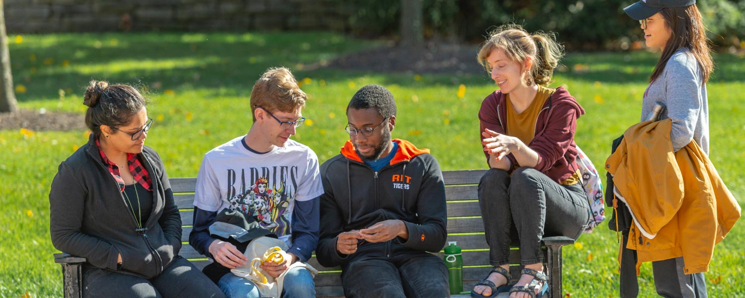 Students conversing on a bench
