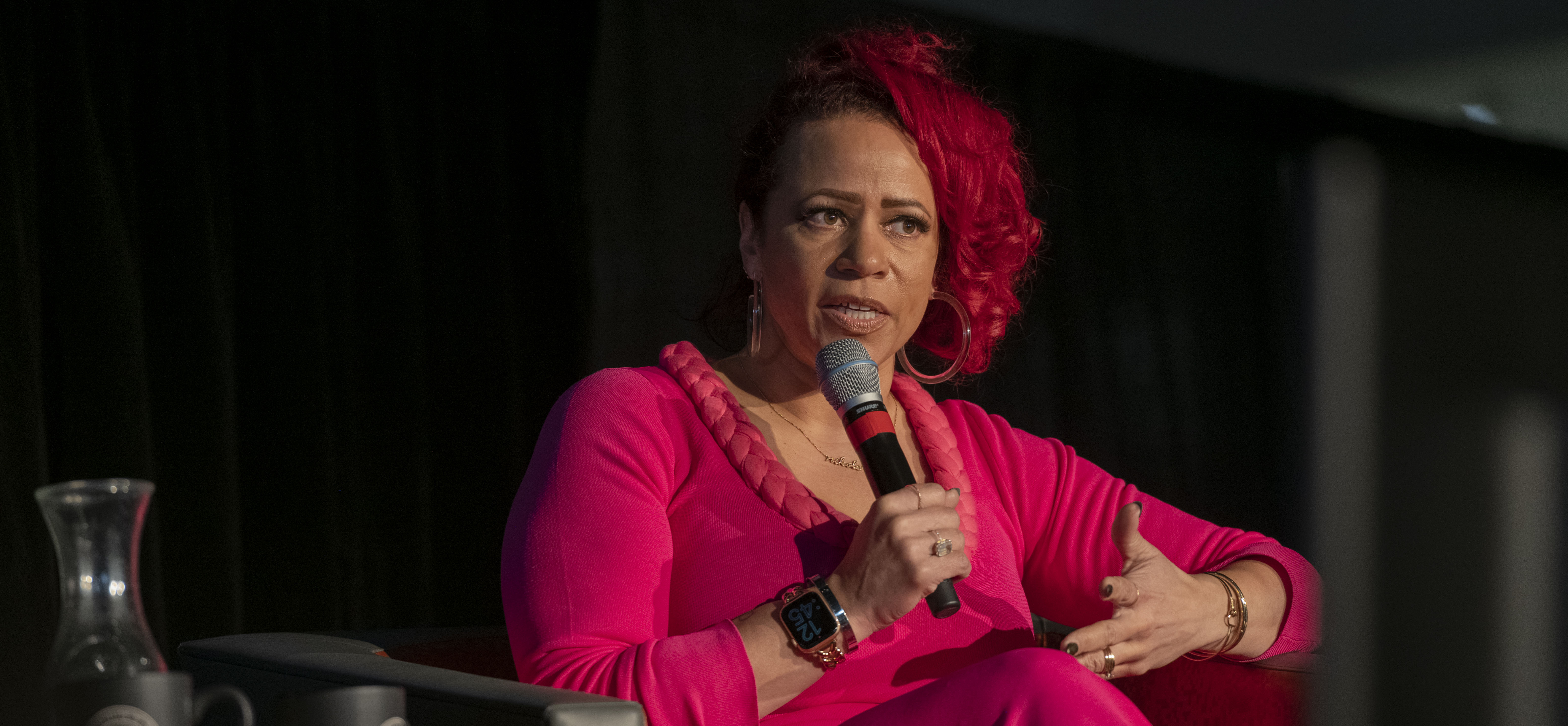 black woman ion pink on stage with microphone