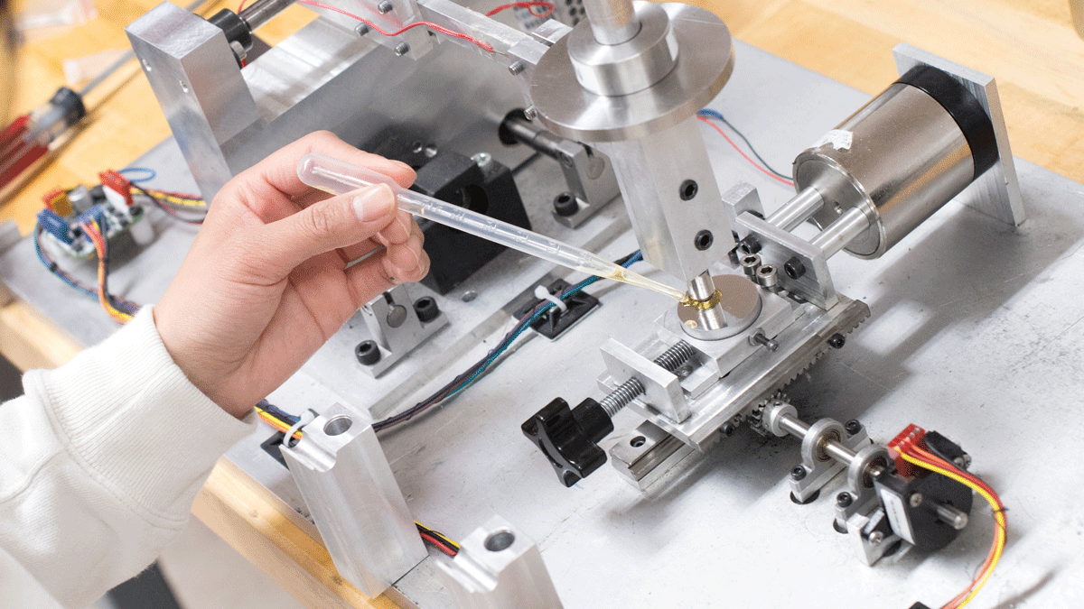 Female engineer dropping a lube on machine