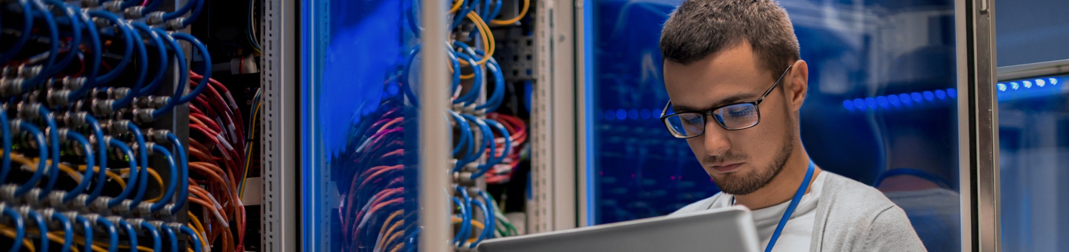 Tech looking at a laptop in a server room