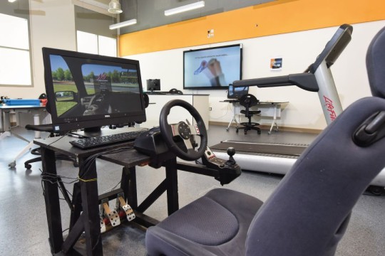 Sim racing rig with steering wheel, pedals, and shifter