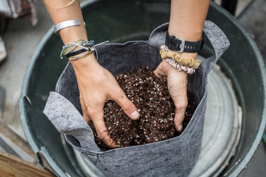 A fifth-year mechanical engineering student mixes soil during biology and botany class available to all students.