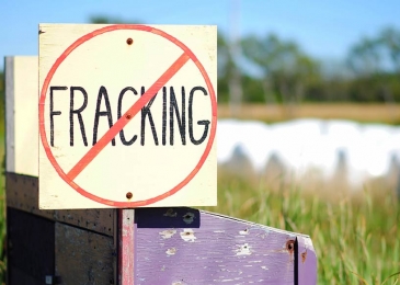 A sign with the word "FRACKING" covered up by a red circle with a slash through it
