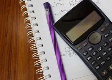 a scientific calculator and pencil on a notebook