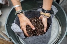 A fifth-year mechanical engineering student mixes soil during biology and botany class available to all students.