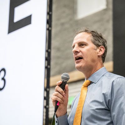 a man stands speaking into a microphone