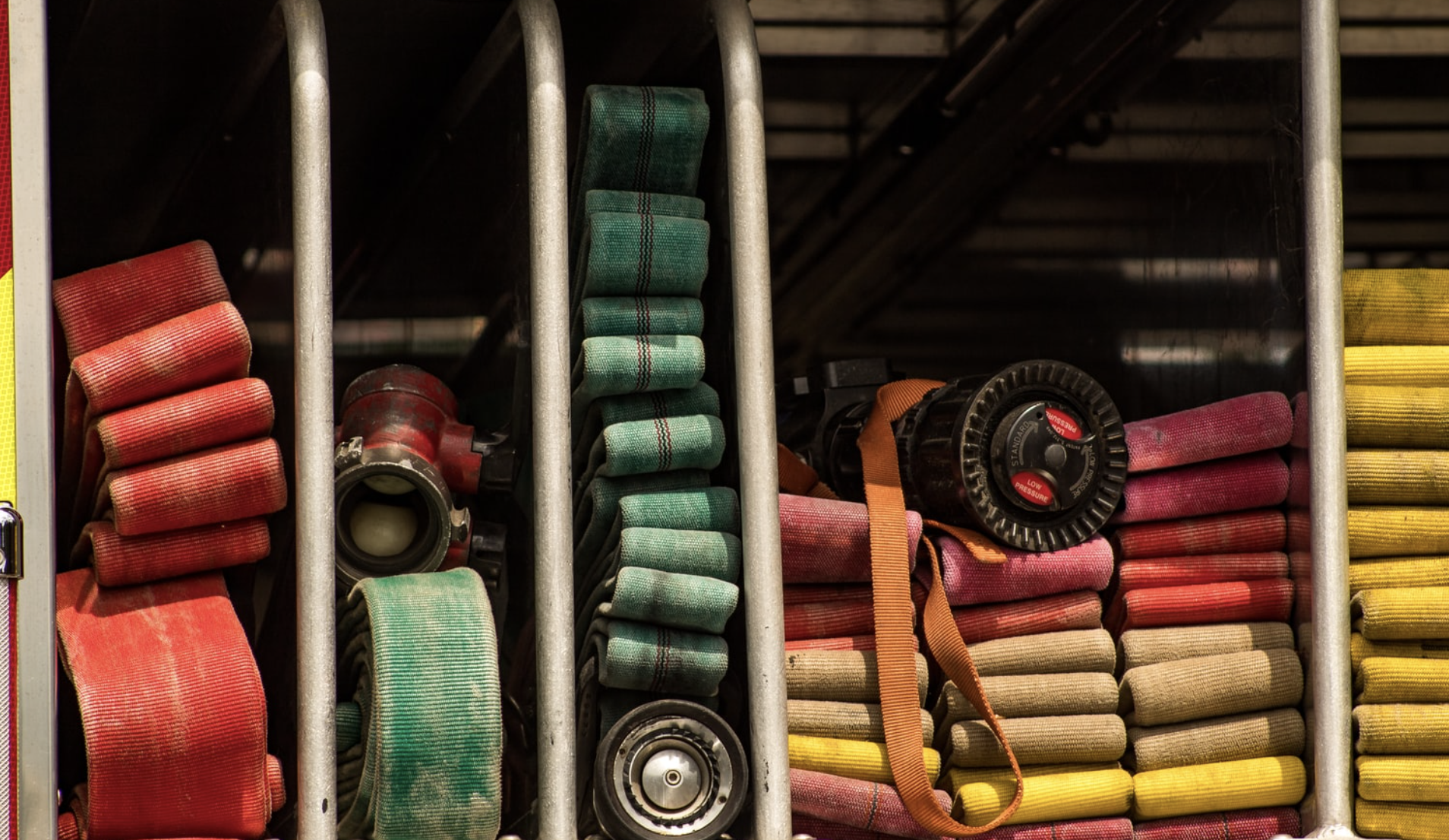 Assortment of red, green, and yellow fire hoses