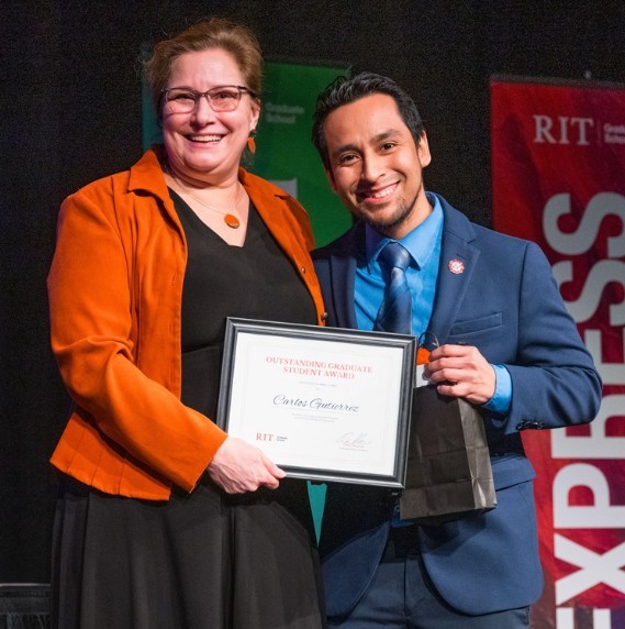 student and faculty pose for photo during a student awards ceremony