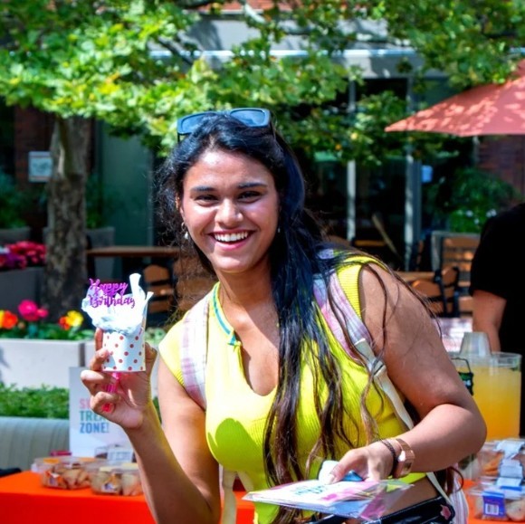 student poses with happy birthday gifts at an Everyone's Birthday celebration