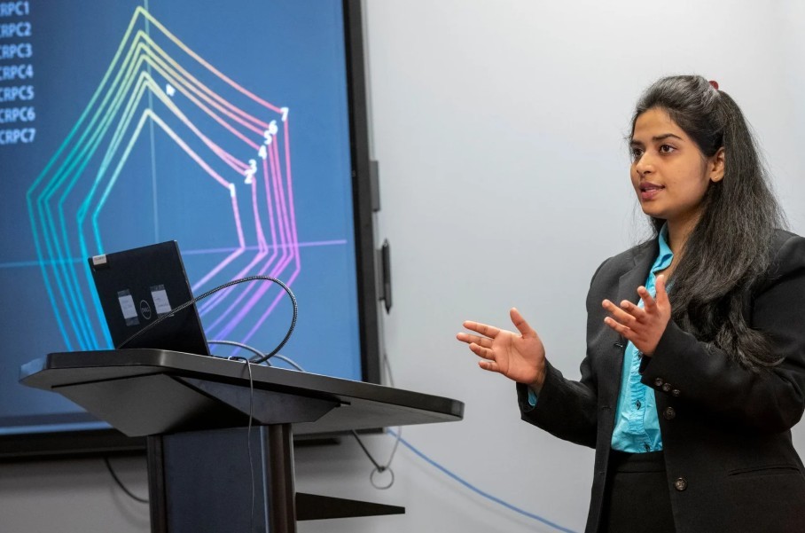 student at right speaks during her presentation at the 2024 graduate showcase