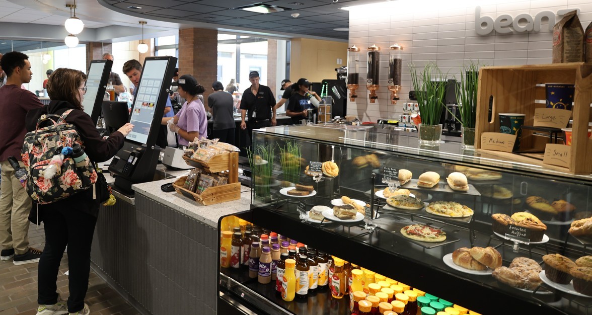 beans cafe display case full of food and students in line to purchase items