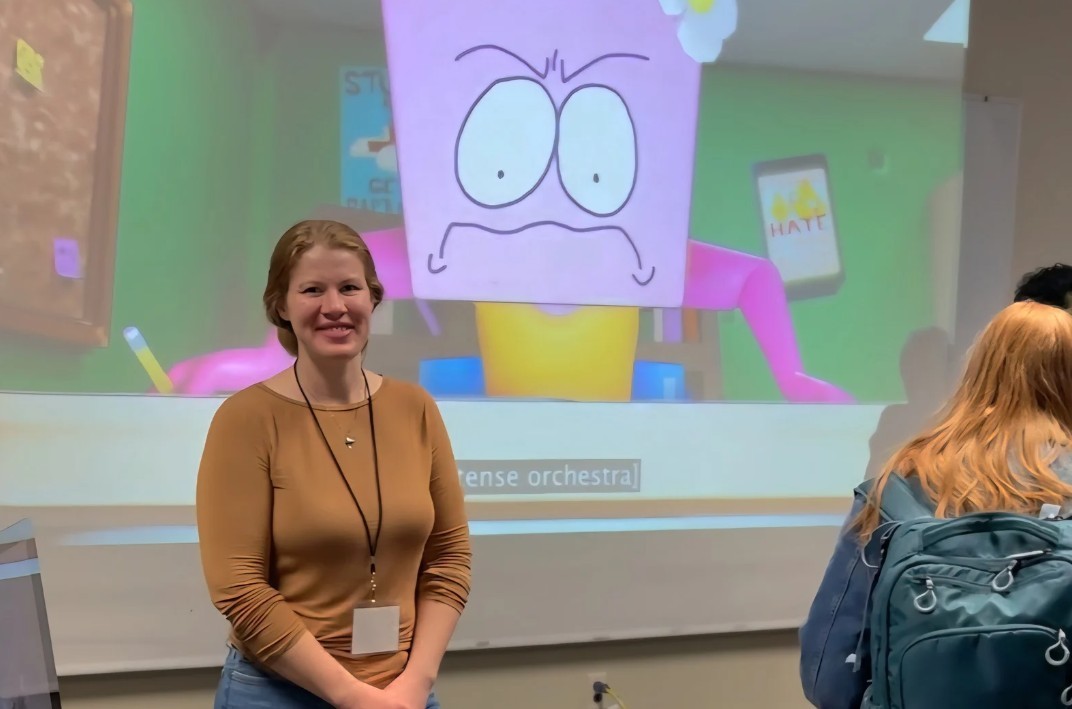 student at left projects her cartoon at right during her presentation at the 2024 graduate showcase