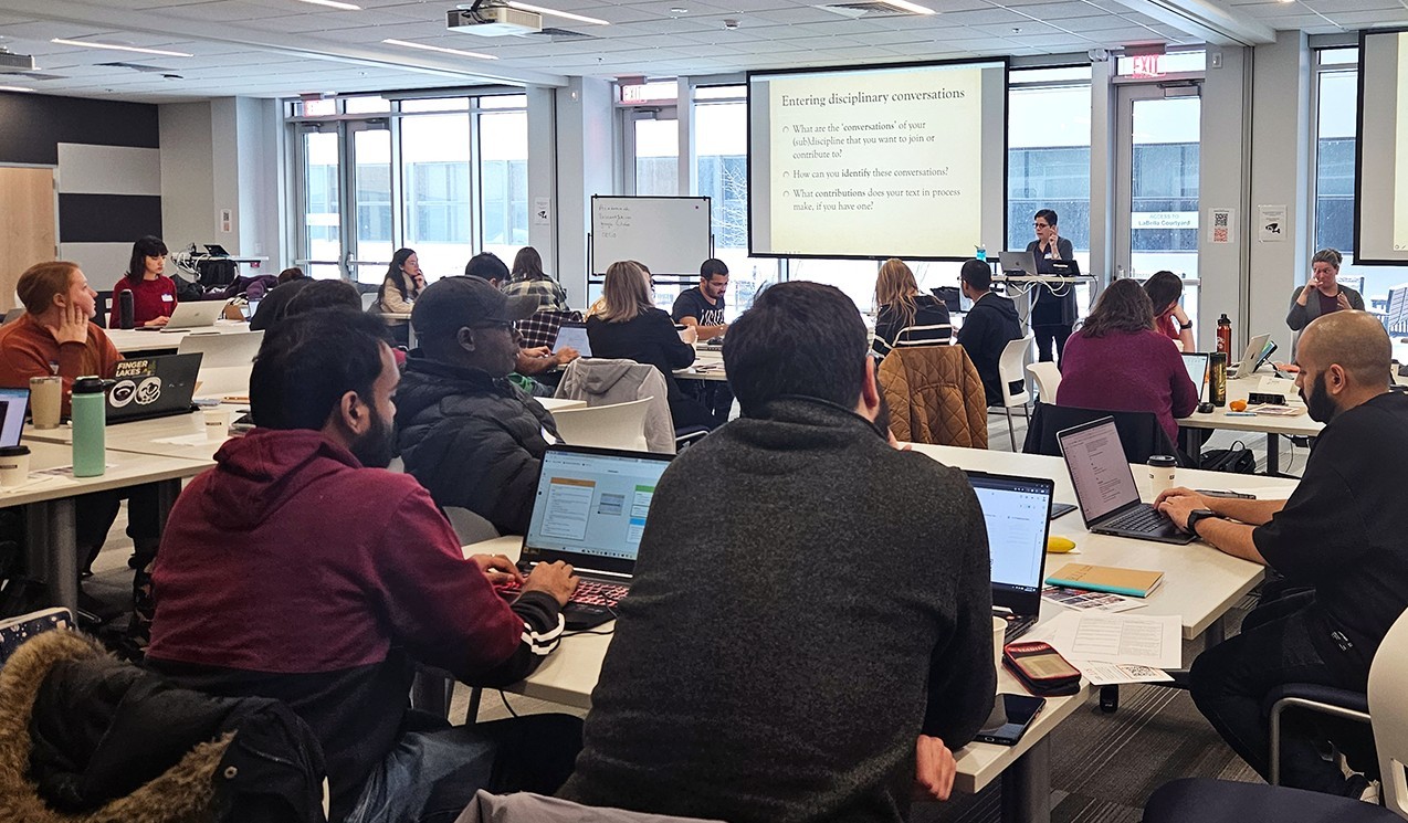 graduate students sitting at tables at the writing retreat listening to the speaker