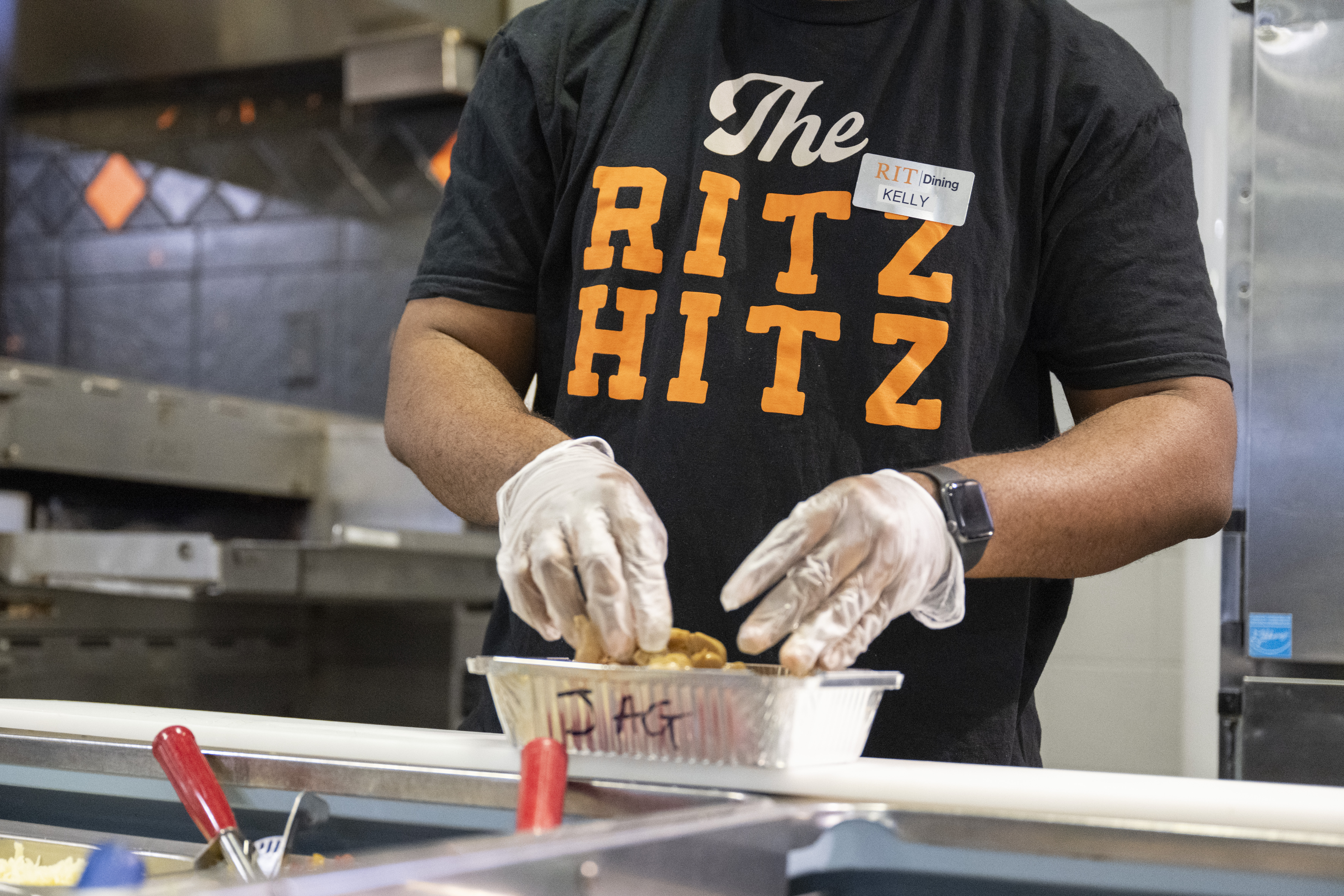 Person wearing a black shirt that says The RITZ HITZ