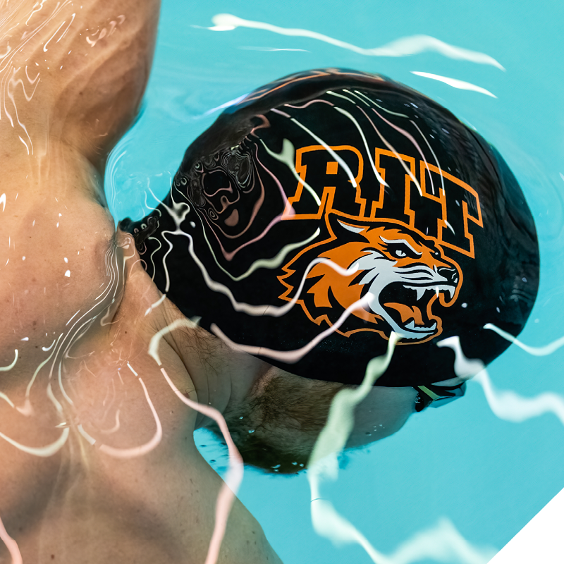 Swimmer wearing an RIT swim cap underwater in a pool.