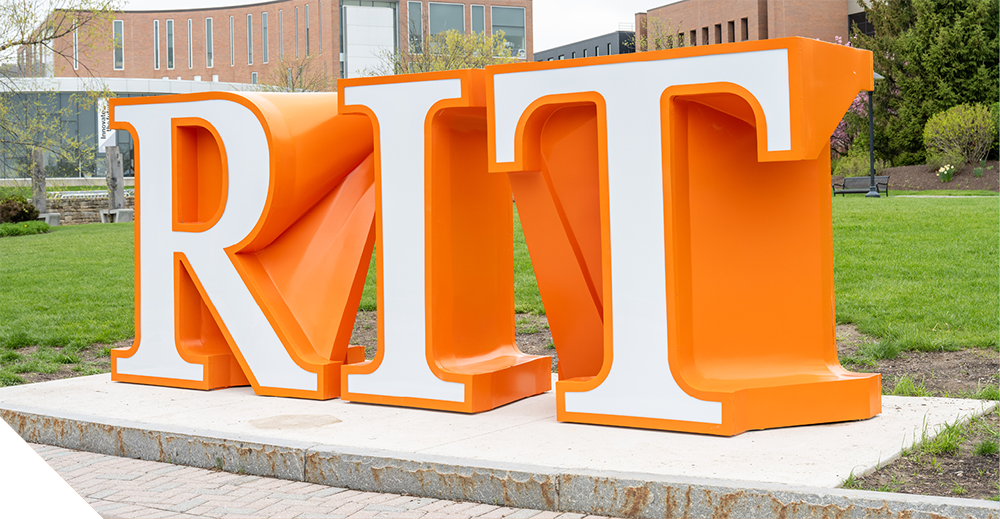 The large orange and white RIT letters displayed on campus lawn outside academic buildings.