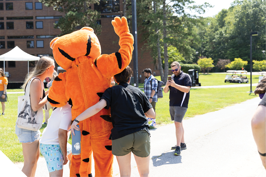Students pose for a photo with RIT's mascot, Ritchie, during a campus welcome event.