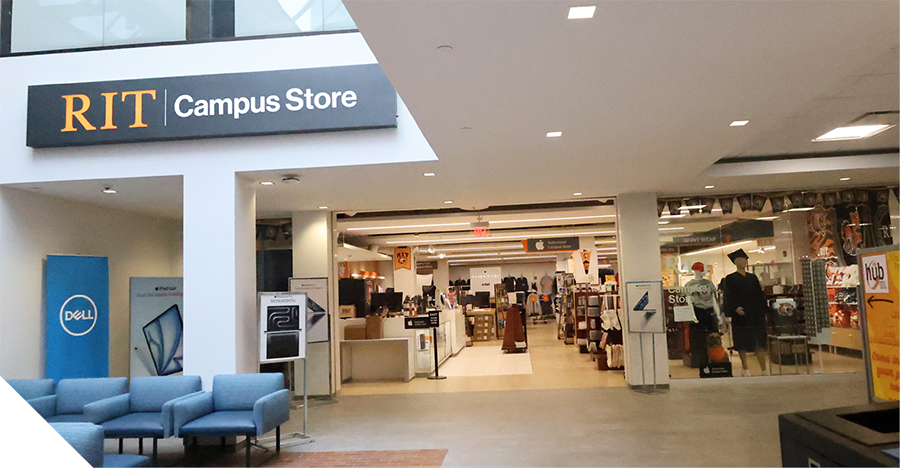 Entrance to the RIT Campus Store inside a bright, modern campus building. A large sign reading “RIT Campus Store” hangs above an open retail area with clothing, merchandise, and displays visible inside.