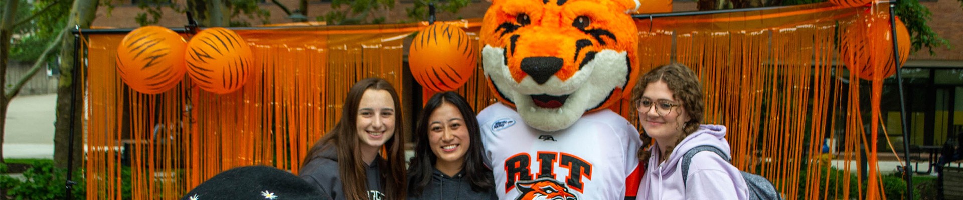 Ritchie the Tiger posing with students