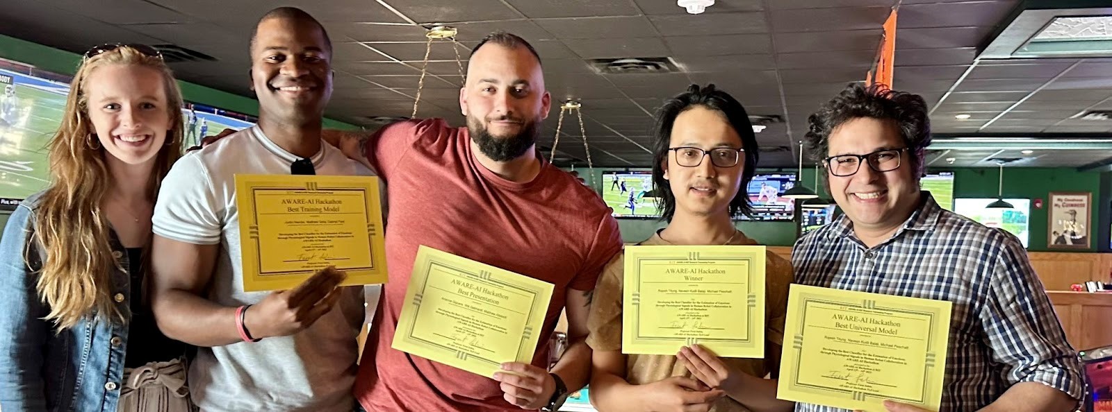 Hackathon winners proudly hold up their yellow award certificates.