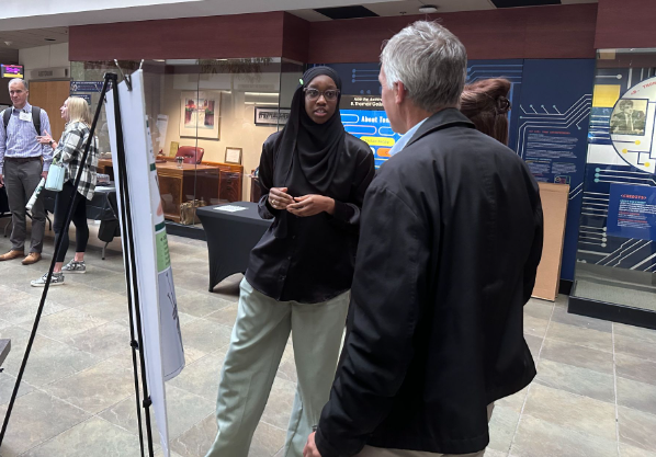 Photo of Kareemat Melaiye next to her research poster.