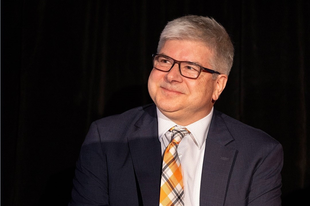 William H. Sanders with suit and checkered orange, black, and white tie