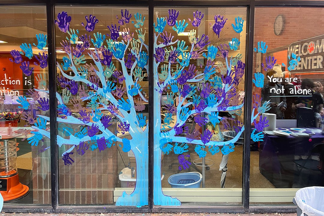 Colorful painting of a tree on glass windows.