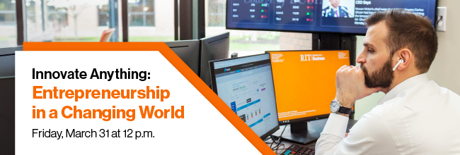 A student working at an office desk with two monitors