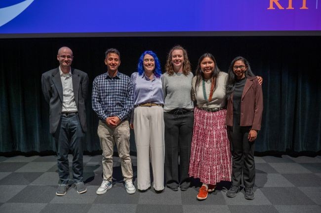 Six RIT doctoral finalists on stage at the 2025 Three Minute Thesis competition, smiling after their presentations.