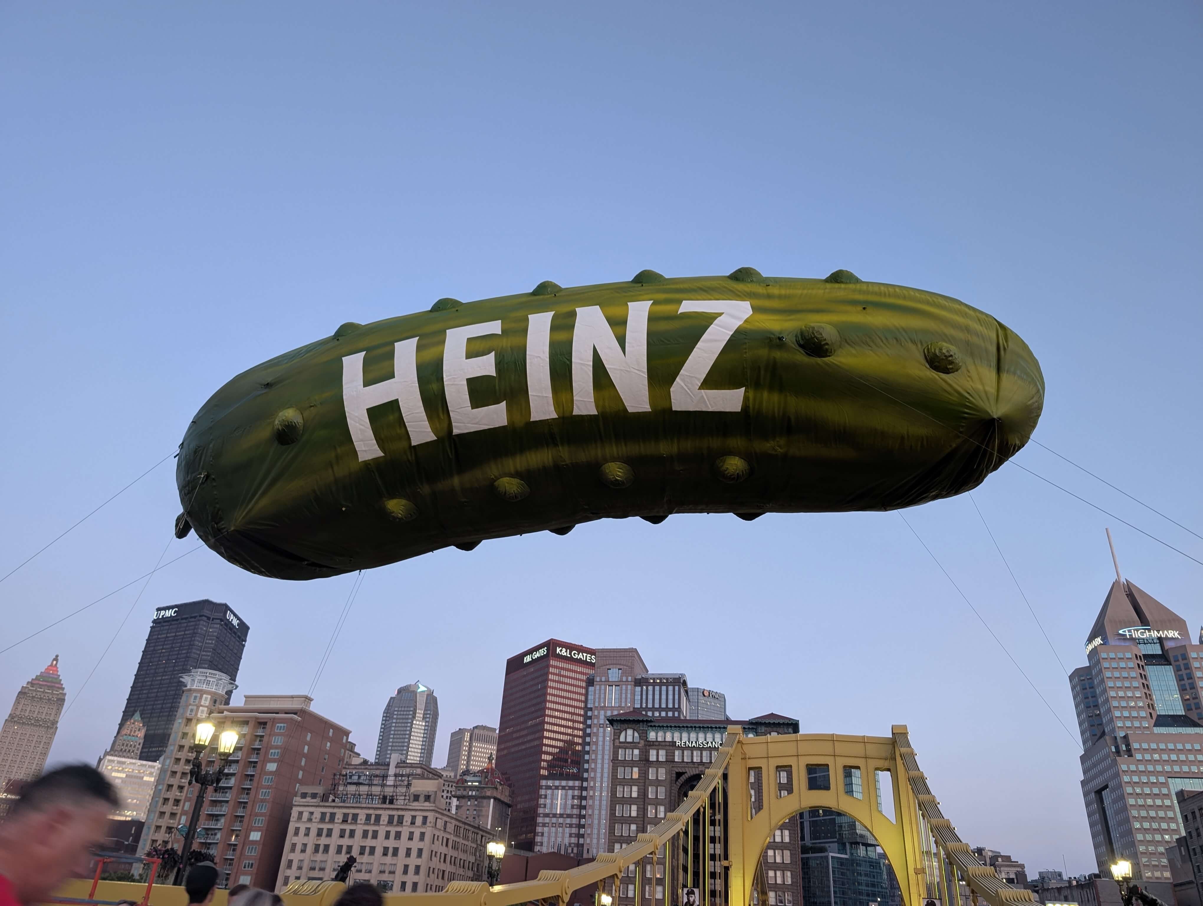 A giant Heinz pickle-shaped balloon floats above Pittsburgh during Picklesburgh.