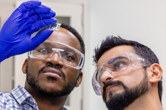 Assistant Professor Ahmad Kirmani, right, and Ph.D. student Tatchen Buh Kum inspect a perovskite solar cell.