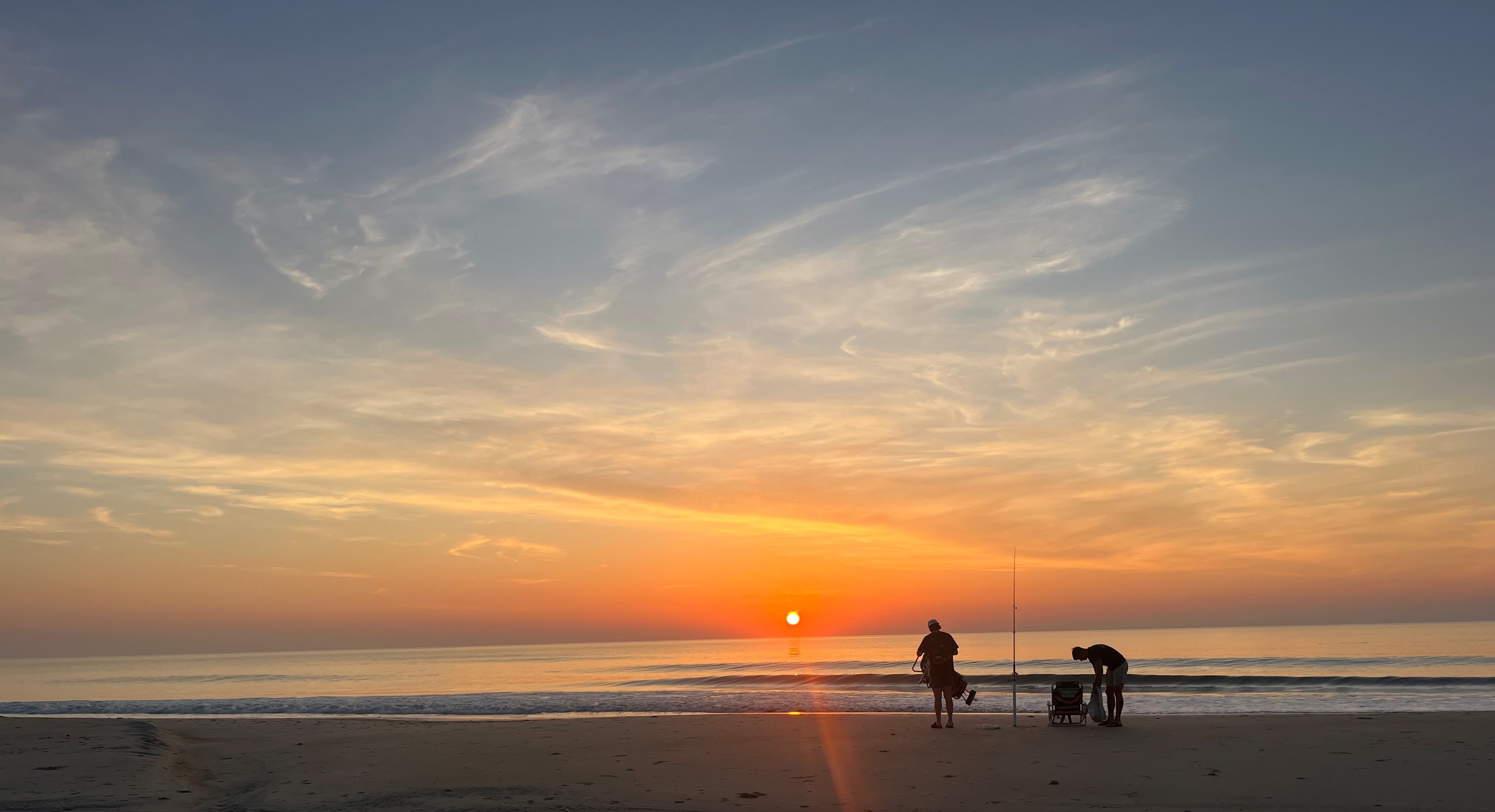 Two men are fishing in the early morning.