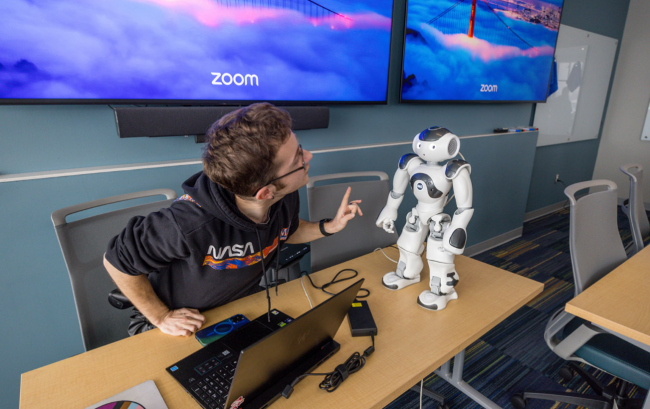 Victor Lockwood, an artificial intelligence master’s degree student, demonstrates the face-tracking capabilities of a robot during the RIT Research Building grand opening on Dec. 2.
