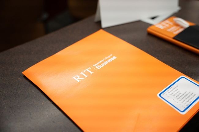 RIT Saunders College of Business folder on a desk.