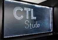 Illuminated sign reading ‘CTL Studio’ displayed on a glass panel.